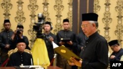 Malaysia's Prime Minister Najib Razak (R) reads his oath declaration as he is sworn in for his second term as prime minister, May 6, 2013.