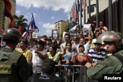Supporters of Venezuela's President Nicolas Maduro hold up photographs of Venezuela's late President Hugo Chavez as they gather Jan. 7, 2016, outside Supreme Court building in Caracas.