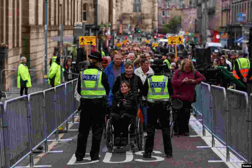 Alison Evans from Derbyshire (in a wheelchair) and Sharon Baum wait in a queue on George IV Bridge to see Queen Elizabeth lying in state at St. Giles' Cathedral in Edinburgh, Scotland.