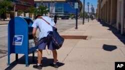 ARHIVA - Poštar prazni sanduče sa poštom u Milvokiju, u državi Viskonsin, 18. avgusta 2020. (Foto: AP)