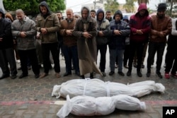 Palestinians pray for the relatives killed in the Israeli bombardments of the Gaza Strip in front of the morgue at Al-Aqsa hospital in Deir al-Balah, Gaza Strip, Feb. 18, 2024.