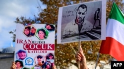FILE - People hold placards bearing portraits of Iranian rapper Toomaj Salehi, right, who was arrested in Iran, and portraits of children who were killed during protests in Iran, during a rally in support of Iranians in Istanbul, Nov. 26, 2022.