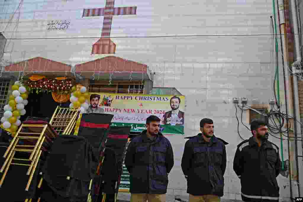 Police personnel stand guard outside the rehabilitated Saint John Church, months after attacks over alleged blasphemy, in Jaranwala, Pakistan, Dec. 25, 2023.