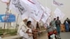 FILE - Elderly men sit under Taliban flags as Afghanistan's de facto rulers mark the second anniversary of the withdrawal of U.S.-led troops from the country, in Kandahar, south of Kabul, Aug. 15, 2023.