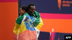 Ethiopia's Tamirat Tola (R) and Kenya's Hellen Obiri celebrate winning the 52nd Edition of the New York City Marathon on Nov. 5, 2023.