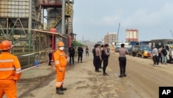 资料照片：印度尼西亚中苏拉威西岛莫罗瓦利的青山不锈钢有限公司冶炼厂发生爆炸后，警察和工人站在现场附近。（2023年12月24日）