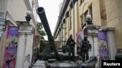 FILE - Fighters of Wagner private mercenary group stand on a tank outside a local circus near the headquarters of the Southern Military District in the city of Rostov-on-Don, Russia, June 24, 2023.