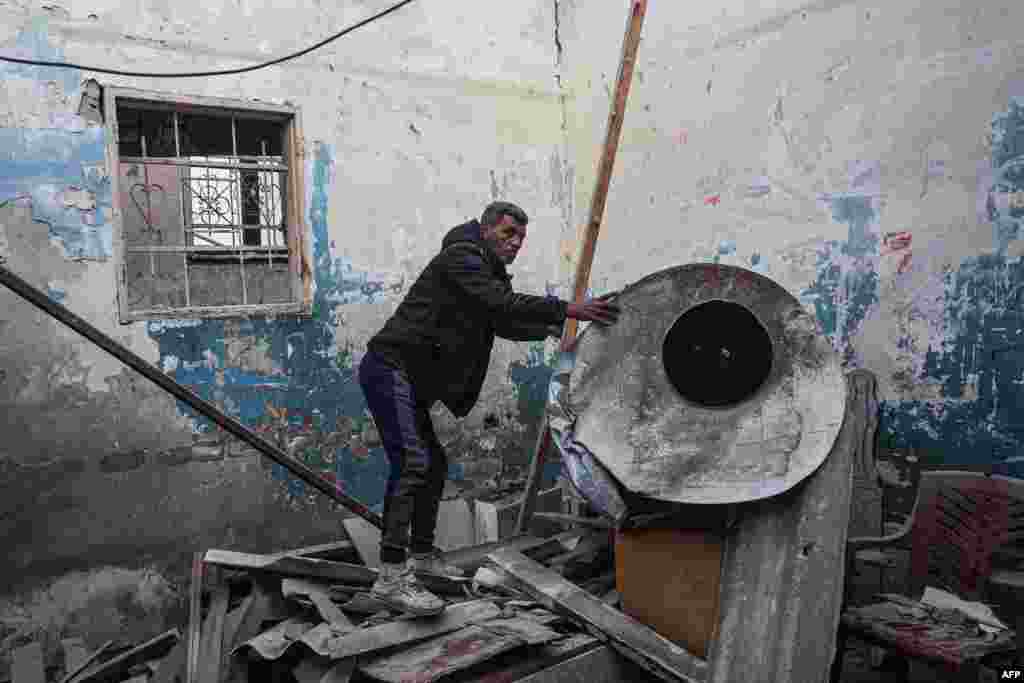 A man salvages items from his damaged home, following overnight Israeli bombardment in Rafah in the southern Gaza Strip, Feb. 25, 2024.