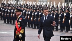 Sweden's King Carl XVI Gustaf, left, and French President Emmanuel Macron inspect the Grenadier Guards during a welcome ceremony at the Royal Palace amid Macron's state visit, in Stockholm, Jan. 30, 2024. (Claudio Bresciani/TT News Agency/via Reuters)