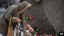 A woman pays tribute to Alexey Navalny at the monument where the first camp of the Gulag political prison system was established in St. Petersburg, Russia, Feb. 21, 2024. Navalny, the most famous Russian opposition leader, died in prison Feb. 16, at 47.