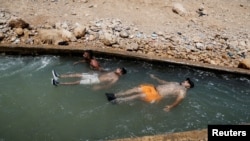 Palestinians cool off during a heat wave, in al-Oja springs near Jericho in the Israeli-occupied West Bank, July 18, 2023.
