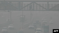 Commuters make their way along a road amid heavy smoggy conditions in New Delhi, Nov. 5, 2023. 