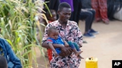 Abdikadir Omar holds one of his children at Dadaab refugee camp in northern Kenya, July 13, 2023. 
