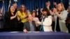State officials applaud Colorado Gov. Jared Polis after he signed the first of three bills that enshrined protections for abortion and gender-affirming care, April 14, 2023, in the State Capitol in Denver.