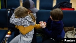 Anastasiia holds her daughter and son — who went to a Russian-organized summer camp from non-government controlled territories and were then taken to Russia — after they returned via the Ukraine-Belarus border, in Kyiv, Ukraine, April 8, 2023. 