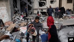 Palestinians salvage their belongings after an Israeli strike in Kahan Younis, Gaza Strip, Jan. 12, 2024. 