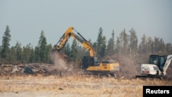 Workers clear trees to create a fire break near Yellowknife after a state of emergency was declared due to the proximity of a wildfire, in Yellowknife, Northwest Territories, Canada, Aug. 16, 2023.