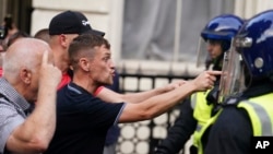 Protesters confront police officers during a protest in Whitehall, London, on July 31, 2024, following the fatal stabbing of three children at a dance and yoga class on Monday in Southport.