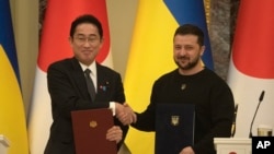 FILE - Japanese Prime Minister Fumio Kishida, left, and Ukrainian President Volodymyr Zelenskyy, greet each other after the signing of joint documents in Kyiv, Ukraine, March 21, 2023.