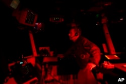 The Air Boss of the USS Dwight D. Eisenhower oversees flight deck control operations from the bridge of the aircraft carrier in the Red Sea, June 11, 2024.