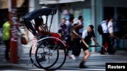 Rickshaw puller Akina Suzuki, 19, drives a rickshaw around Asakusa district in Tokyo, Japan, June 18, 2023. (REUTERS/Issei Kato)