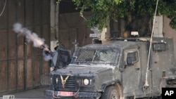An Israeli border police officer fires tear gas during an Israeli army raid near Nablus, in the West Bank, May 13, 2023. The raid sparked a firefight that killed two Palestinians.