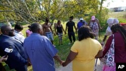 Residents gather for a prayer near the scene of a mass shooting at a Dollar General store in Jacksonville, Florida, Aug. 26, 2023.