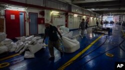 Workers prepare a ship of the Freedom Flotilla Coalition at Tuzla seaport in Istanbul, Turkey, April 19, 2024. A three-ship flotilla trying to reach Gaza with humanitarian aid from Turkey was prevented from sailing by Guinea-Bissau authorities, said flotilla organizers.
