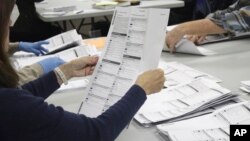 FILE - An election worker examines a ballot on May 19, 2022, in Oregon City, Oregon. No Labels, a group that could shake up the 2024 U.S. presidential race with a bipartisan "unity ticket," secured access to the ballot in Oregon on March 10, 2023.