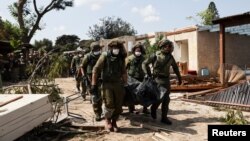 Izraelski vojnici iznose vreće sa telima ubijenih stanovnika kibuca Kfar Aza posle napada militantnog pokreta Hamas (Foto: Reuters/Violeta Santos Moura)