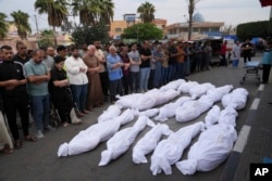 Palestinians pray for their relatives killed in the Israeli bombardment of the Gaza Strip in Deir al Balah, Oct.27, 2023.