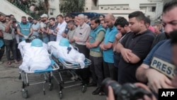 Mourners attend the funeral of fellow journalists Said al-Taweel and Mohammed Sobboh who were killed in an Israeli airstrike on Gaza City on Oct. 10, 2023. 
