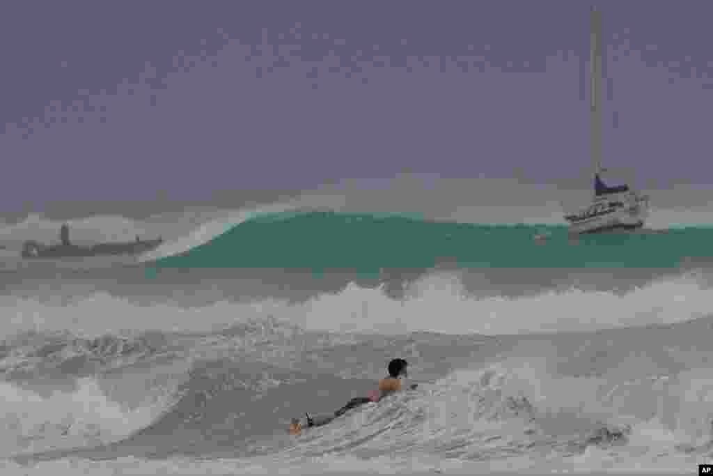 A surfer braves the waves in Carlisle Bay as Hurricane Beryl passes through Bridgetown, Barbados.