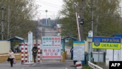 FILES - A woman arrives from Ukraine through Kuchurgan-Pervomaisc, Ukraine-Moldova border point, April 15, 2014. Pro-Russian rebels in breakaway region of Transnistria appeals to Russia for protection, Feb. 28, 2024.