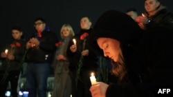 2024年3月22日，在克里米亚辛菲罗波尔市中心，人们献上鲜花，点燃蜡烛，纪念莫斯科音乐会枪击事件的受害者 .(法新社）