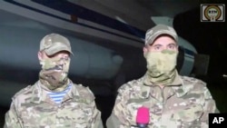 In this image taken from video from RTN, unidentified Russian military instructors speak to media on their arrival in Niamey, Niger, April 10, 2024. (RTN via AP)