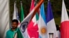 A worker carries Indian national flag to place it with those of other participating countries at the opening session of the G20 foreign ministers meeting, in New Delhi, India, March 2, 2023.