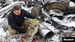 A representative from the prosecutor's office shows parts of an unidentified missile, which Ukrainian authorities believe to have been made in North Korea and used in a strike in Kharkiv earlier this week, Jan. 6, 2024. 