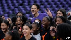 Phoenix Mercury center Brittney Griner (42) joins a group of girls for a photo on the court before a WNBA basketball game against the Los Angeles Sparks in Los Angeles, May 19, 2023.