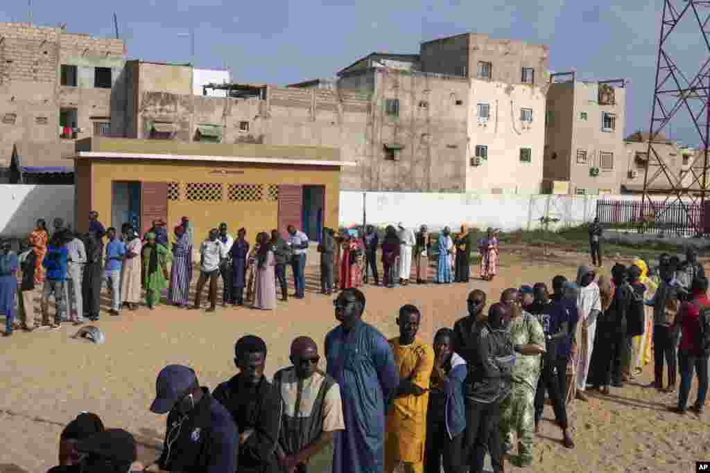 People wait to cast their votes outside a polling station during the presidential elections, in Dakar, Senegal, March 24, 2024. 
