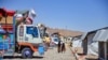 Afghan refugees walk through a registration center upon their arrival from Pakistan in Takhta Pul district of Kandahar province on May 22, 2024. 