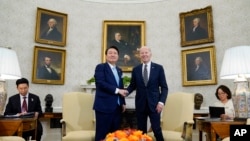 조 바이든 미국 대통령과 윤석열 한국 대통령이 26일 백악관 정상회담에 앞서 집무실에서 악수를 나누고 있다.