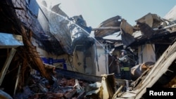 A firefighter works inside the burnt-out building of the University of Economics and Trade, which was reportedly hit by shelling in the course of Russia-Ukraine conflict in Donetsk, Russian-controlled Ukraine, Aug. 6, 2023. 