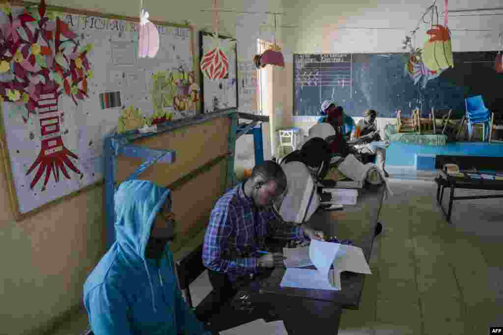 Commission Electorale Nationale Autonome (CENA) officials check the voters' rolls at a polling station in a school in HLM Grand Medine on the outskirts of Dakar, Senegal, March 24, 2024.