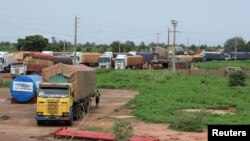 Trucks carrying food, humanitarian aid, and industrial equipment wait due to sanctions imposed by Niger's regional and international allies, in the border town of Malanville, Benin, Aug. 18, 2023.
