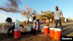 Citizens dig small holes at the shore to get pure water at the banks of the White Nile as clashes between the Paramilitary Rapid Support Forces and the Sudanese army continue, in Khartoum, May 6, 2023.