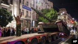 Members of the Wagner Group military company load their tank onto a truck on a street in Rostov-on-Don, Russia, June 24, 2023, prior to leaving an area at the headquarters of the Southern Military District.