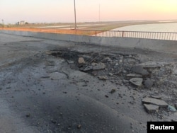 Jembatan Chonhar menghubungkan bagian-bagian wilayah Kherson Ukraina yang dikuasai Rusia ke Semenanjung Krimea. Pejabat ditunjuk Rusia mengatakan kerusakan dalam foto ini sebagai serangan rudal Ukraina, 22 Juni 2023. (Foto: via Reuters)