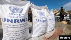 FILE - Displaced Palestinians wait to receive United Nations Relief and Works Agency (UNRWA) aid, amid the ongoing conflict between Israel and the Palestinian Islamist group Hamas, in Rafah, in the southern Gaza Strip, March 7, 2024. 