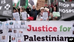 Protesters carry flags and banners outside the International Court of Justice in The Hague, Netherlands, Jan. 12, 2024.